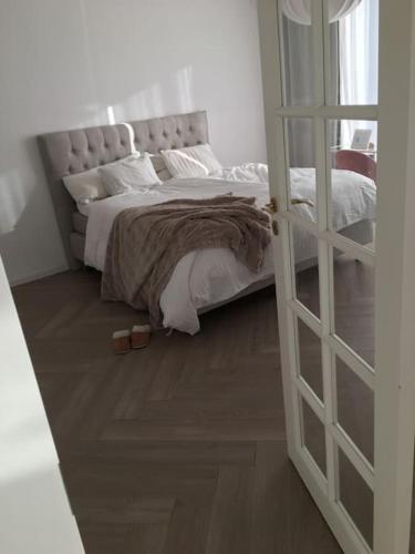 哈尔姆斯塔德Stan- och strandnära poolvilla.的一间卧室配有一张铺有木地板的床。