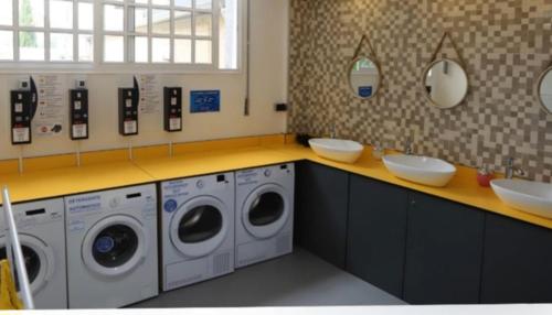 卡尔达斯·德·雷斯ALBERGUE de Caldas de Reis URRACA的洗衣房配有3台洗衣机和2个水槽