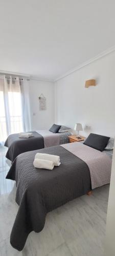 莫莱拉Luxury apartment in the heart of Moraira & 200mtrs from the sea的一间卧室配有三张床和毛巾