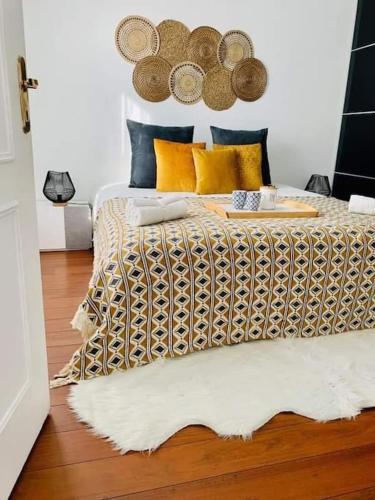 维勒帕里西L’Emeraude的一间卧室配有黄色和蓝色枕头的床