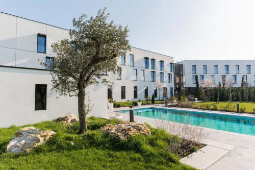 尚特洛普恩布里Hôtel Dali Val d'Europe的公寓大楼设有游泳池和树