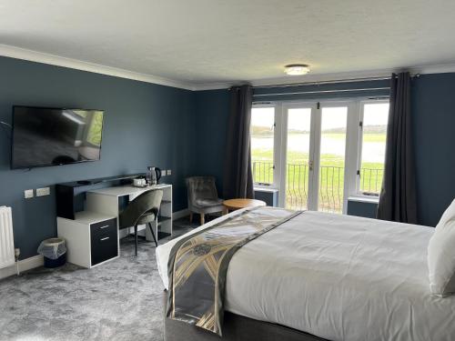 圣艾夫斯Dolphin Hotel Cambridge的一间卧室配有一张床、一张书桌和一个窗户。