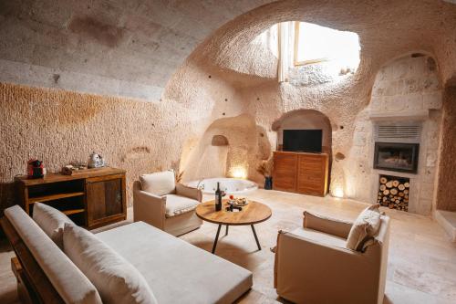 乌奇希萨尔磨石山洞套房酒店的客厅配有沙发和桌子