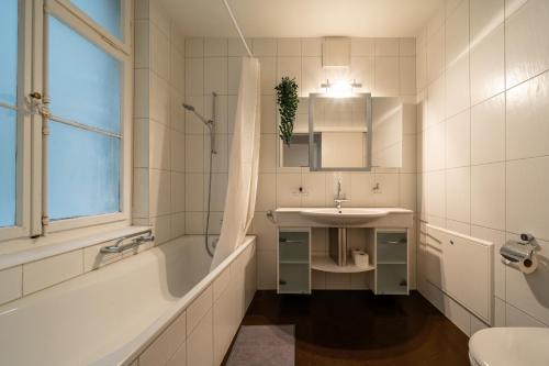 图恩Jewel in the center of Thun's old Town的白色的浴室设有水槽、浴缸和水槽。