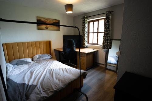 Trimley HeathSevenoaks Guest House的一间卧室配有一张床、一张书桌和一个窗户。