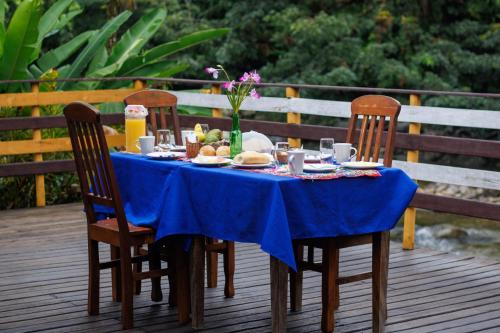 Sertão do TaquariPousada cachoeira de Paraty的一张蓝色桌子,椅子和甲板上的食物