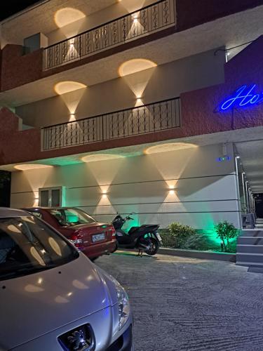 纳夫普利翁Hotel Vasilis的停在一座带摩托车的建筑前面的汽车
