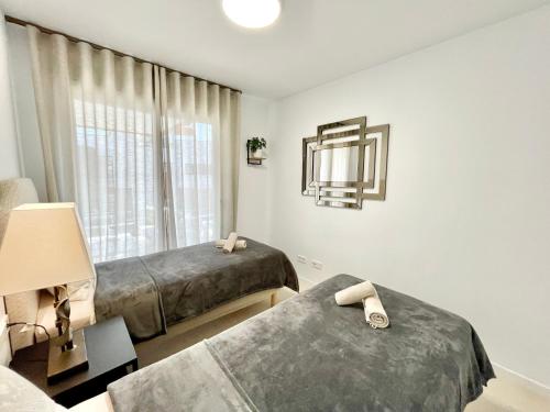 福恩吉罗拉Paradise in Fuengirola的一间卧室设有两张床和窗户。
