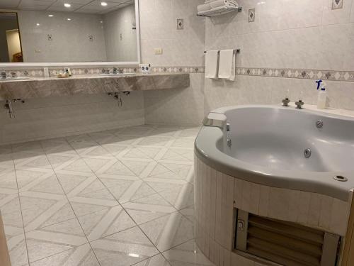 克雷塔罗Hotel Mirage - Centro Histórico de Querétaro的带浴缸、水槽和镜子的浴室