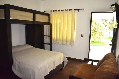El DesengañoSunset的一间卧室配有双层床和滑动玻璃门