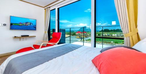 西归浦市博乐姆度假屋的一间卧室设有一张床和一个大窗户