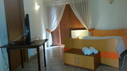 Tarsia伊尔巴洛奈托酒店的一间卧室配有一张带书桌和电视的床。