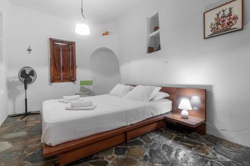 MakrotándalonAegean Cottage Andros的一间卧室配有一张带白色床单的大床
