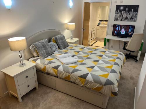 伦敦Entire Apartment - Excel Exhibition Centre O2 Arena London Royal Victoria Canning Town的一间卧室配有一张床和一台电视。