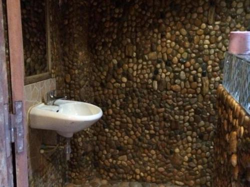 邦隆树冠生态山林小屋的浴室设有石墙和水槽