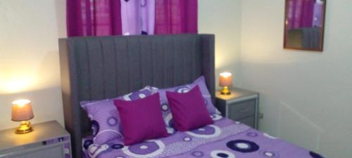 哈拉瓦科阿Maria e Nicola的一间卧室配有紫色床和紫色枕头