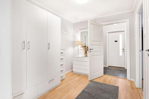 EidsvollCozy and central home near Oslo Gardermoen Airport的白色的房间,设有走廊和白色橱柜