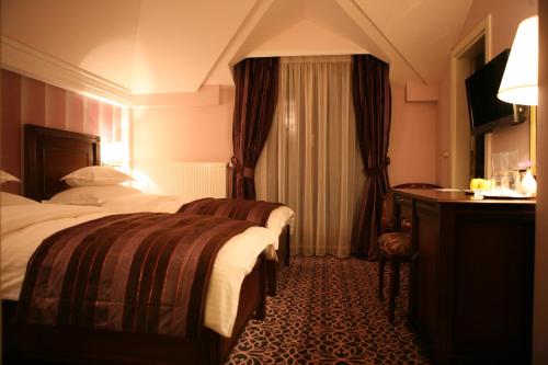 巴尼亚卢卡维多利亚别墅酒店的酒店客房设有两张床和一张桌子。