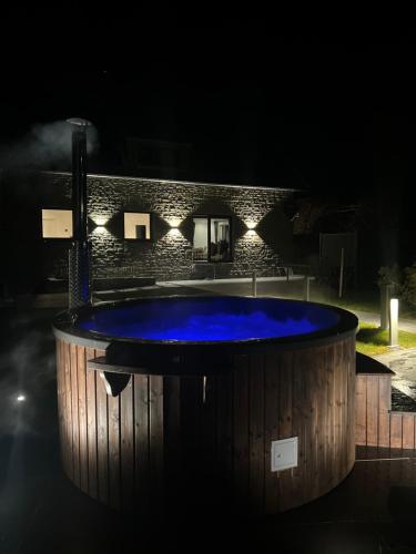 蒙绍Traumfabrik Eifel mit Sauna & Whirlpool的夜间在大楼里设有一个按摩浴缸