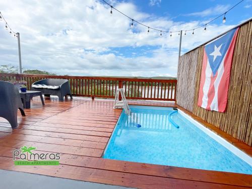 瓜尼卡Palmeras Beach Apartments - Playa Santa的一个带美国国旗的甲板上的游泳池