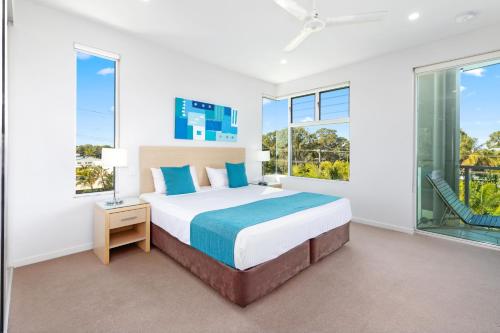 赫维湾阿卡玛度假酒店的一间卧室设有一张大床和大窗户