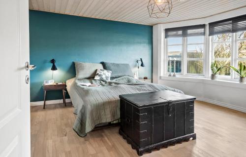 曲博伦5 Bedroom Cozy Home In Thyborn的一间卧室设有一张床和蓝色的墙壁
