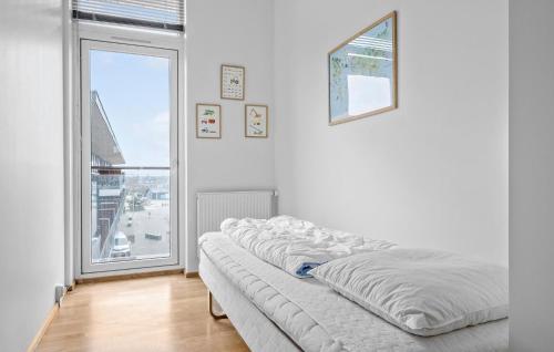 Havneby3 Bedroom Stunning Apartment In Rm的白色客房的一张床铺,设有大窗户