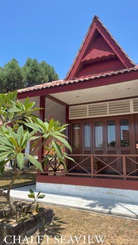马六甲Lovita Tanjung Bidara Beach Resort的一间红色屋顶的小房子