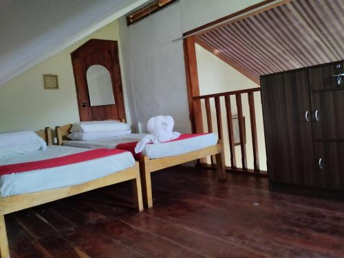 MalaybalayBliss Accommodation的一间卧室配有两张床,卧室上摆放着泰迪熊