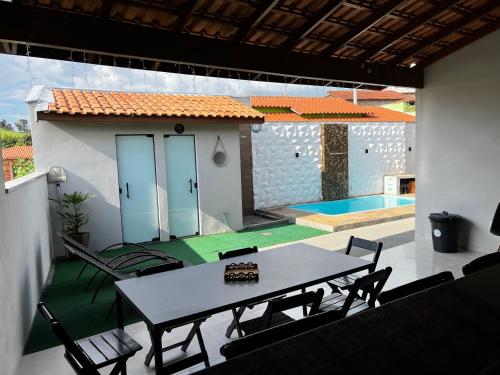索科罗Chacara em Socorro- SP próx ao centro, com piscina e area gourmet的一个带桌椅的庭院和一个游泳池