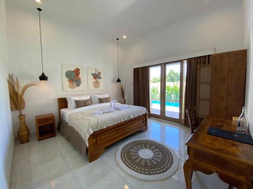 坎古The Jangkar Canggu Guesthouse & Villa的一间卧室配有一张床、一张书桌和一个窗户。