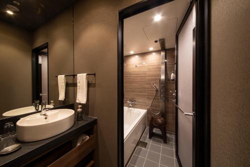 大阪Hotel Keihan Tenmabashi Ekimae的一间带水槽、浴缸和卫生间的浴室