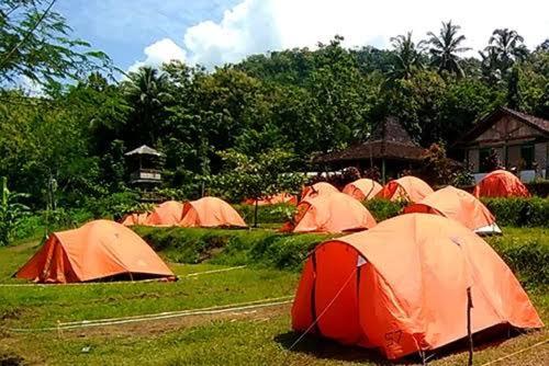 武吉丁宜Tapian Asri Camp的一群帐篷坐在草地上