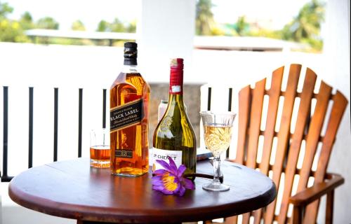 尼甘布Negombo Palace的两瓶葡萄酒和一张桌子上的一杯