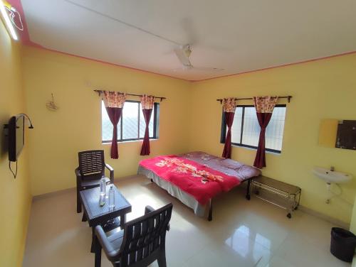 戴维格Shri Krupa Homestay的一间卧室配有一张床、一张桌子和一个水槽