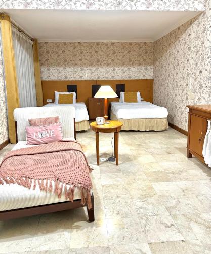 库塔Turtledove Guesthouse的酒店客房设有两张床和一张桌子。