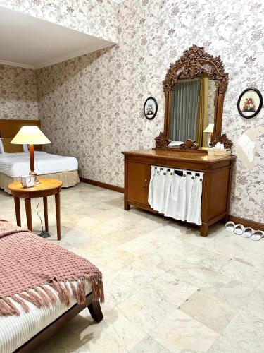 库塔Turtledove Guesthouse的一间卧室配有一张床、梳妆台和镜子