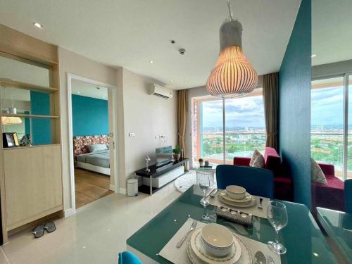 南芭堤雅Grand Caribbean Condo Resort Pattaya 19 floor的一间带餐桌的客厅和一间客厅。