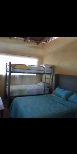 El CoacoyulCASA CERCA DEL MAR ZIHUATANEJO的带窗户的客房内的两张双层床