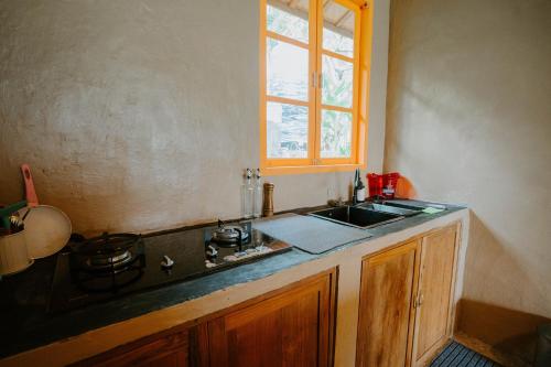 SilebengRavelyn House的厨房配有水槽、炉灶和窗户。