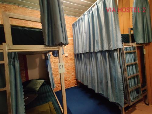 巴色Via Hostel Pakse的客房设有两张双层床和窗帘