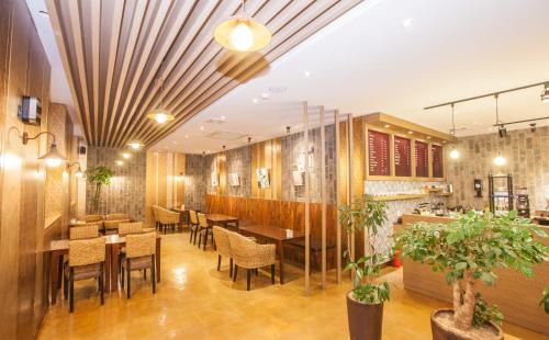 全州市Pungnam Tourist Hotel的餐厅拥有木墙和桌椅
