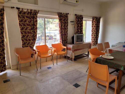 克久拉霍Hotel Lakeside的客厅配有橙色椅子和电视