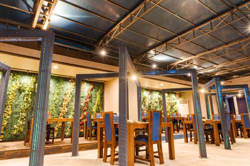 白滨XYZ私人Spa中心及海滨度假酒店 的餐厅墙壁上摆放着桌椅和植物