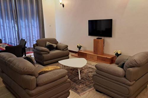 莫希Ellyz Home Stay的客厅配有2张沙发和1台平面电视