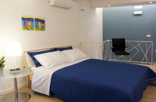 那不勒斯那不勒斯卢尔度假屋的一间卧室配有蓝色的床和椅子