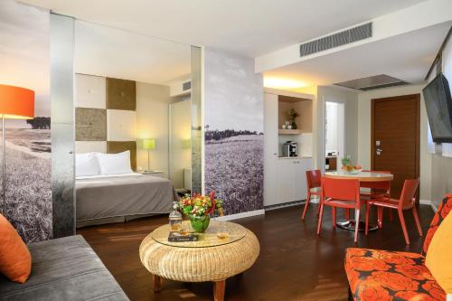 阿萨夫哈罗芬班古里昂机场萨杜特酒店 - 阿特拉斯精品酒店的酒店客房配有一张床铺和一张桌子。