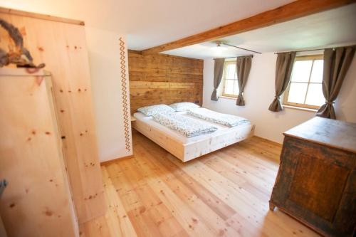 塞纳莱斯Innerforchhof的铺有木地板的客房内设有一间卧室和一张床。