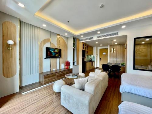 归仁Wins House - FLC Sea Tower Quy Nhơn的一间带白色沙发的客厅和一间带厨房的客厅