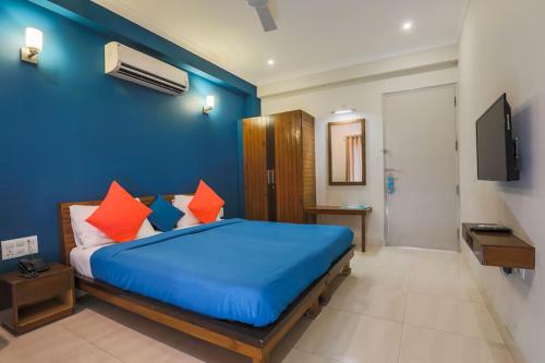 古尔冈Hotel Wedlock 39的蓝色卧室配有带橙色枕头的床